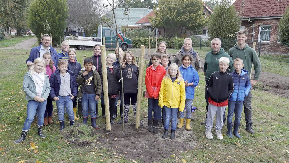 Schülerinnen und Schüler der Grundschule Sonnentau Elisabethfehn pflanzten auf der Streuobstwiese an der Pirolstraße Obstbäume. Landschaftsbauer Stephan Wiemken half dabei. Foto: Passmann