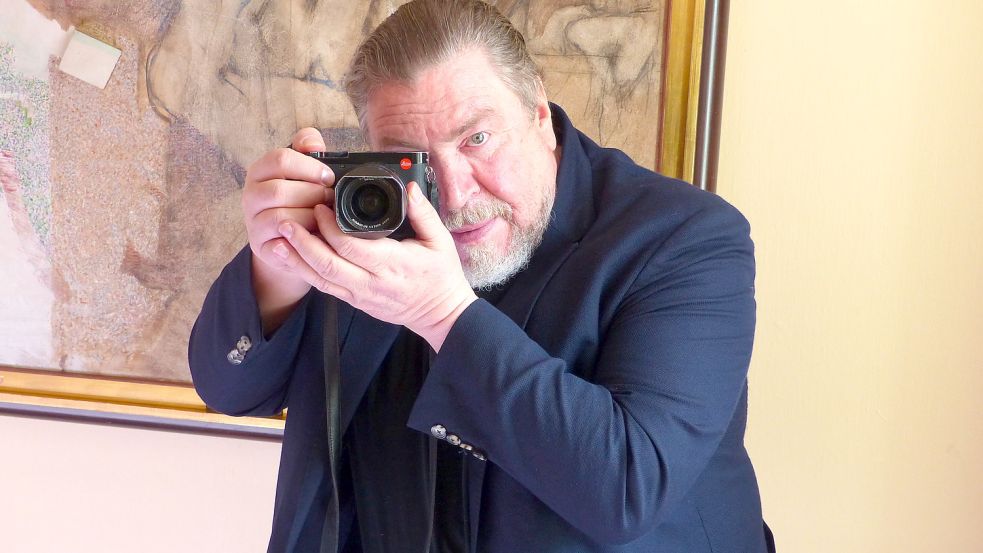 Hobby-Fotograf Armin Rohde posiert beim Interview mit seiner Kamera. Foto: Manfred Ertel