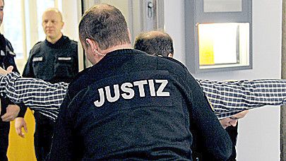 Justizbeamte kontrollieren am Mittwoch Zuschauer im Kieler Landgericht. Foto: dpa