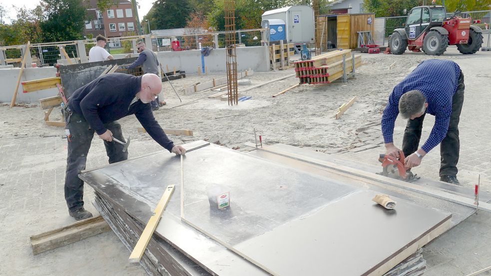 Im südwestlichen Bereich des Marktplatzes in Rhauderfehn baut die Gemeinde zurzeit ein Mehrzweckgebäude mit einer kleinen, teilweise überdachten Bühne für Veranstaltungen. Unser Bild zeigt Mitarbeiter des Bauunternehmens Schilder aus Ostrhauderfehn mit Bauleiter Ralf Brinker (links). Foto: Wieking