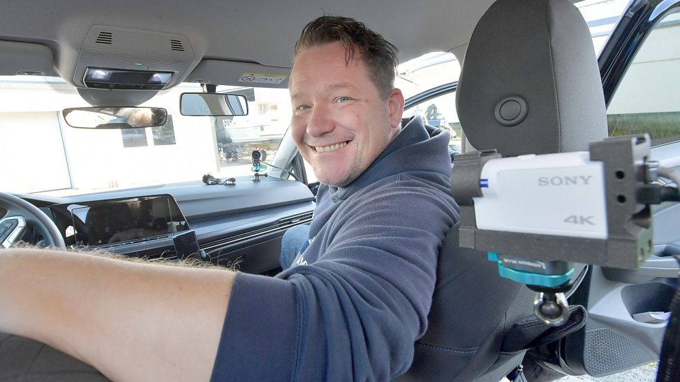 Sebastian Müller sitzt in seinem Fahrschulauto. Zwei Kameras hat er aufgebaut, die ihn von vorne und hinten aufzeichnen. Foto: Ortgies