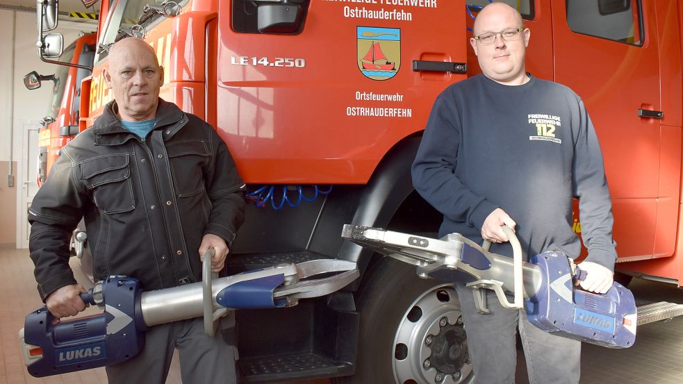 Ostrhauderfehns Ortsbrandmeister Ralf Ecken (links) und der künftige Pressesprecher André Visser zeigen das neue Rettungsgerät, das aus Schere und Spreizer besteht. Foto: Zein