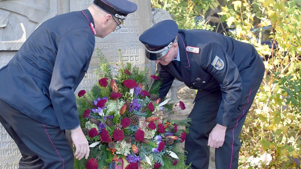 Vertreter der Feuerwehr Westrhauderfehn legten zum Gedenken einen Kranz am Ehrenmal nieder. Foto: Ammermann