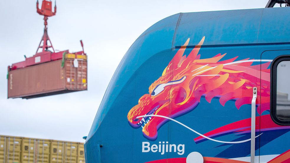 Ein Container wird hinter einer Lokomotive mit einem asiatischen Drachenkopf nach der Ankunft eines Schiffs der·Seidenstraßen-Verbindung zwischen China und Deutschland im Hafen von Mukran entladen. Foto: Jens Büttner