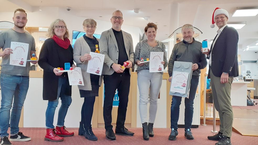 Die Ausrichter des 1. Fehntjer Lego-Bauwettbewerbs freuen sich auf tolle Bauwerke: Thorben Johannsen (von links, Detail Cars), Frauke Eilers (Zweirad Teutenberg), Helga Kruse (Fehnbuch), Thomas Kruse (Kruse-Moden), Anja Teichler (TUI Reisecenter Bohlmann), Ludwig Meinders (Grubens Rollenmarkt) und Sibo Müller (Sibo Müller Sehzentrum Hörzentrum GmbH).