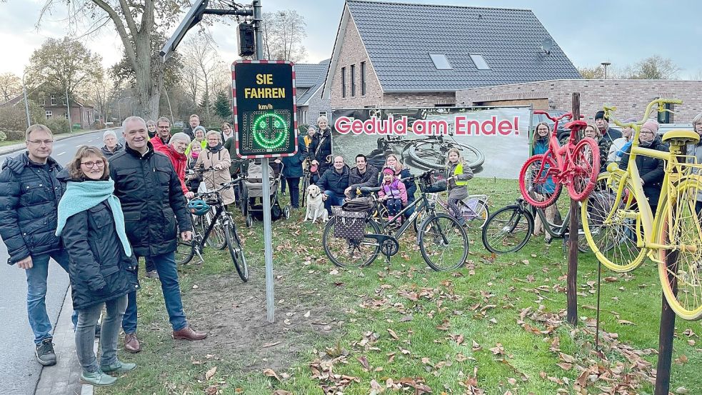Bauunternehmer Dirk Gruben (vorne, von links), Potshausens Ortsvorsteherin Helga Meyer, Ostrhauderfehns Bürgermeister Günter Harders und viele Bürger - zum Teil mit Rad - kamen zur Einweihung der neuen Tempo-Anzeigen. Und um erneut für den Radweg mobil zu machen. Foto: Janßen