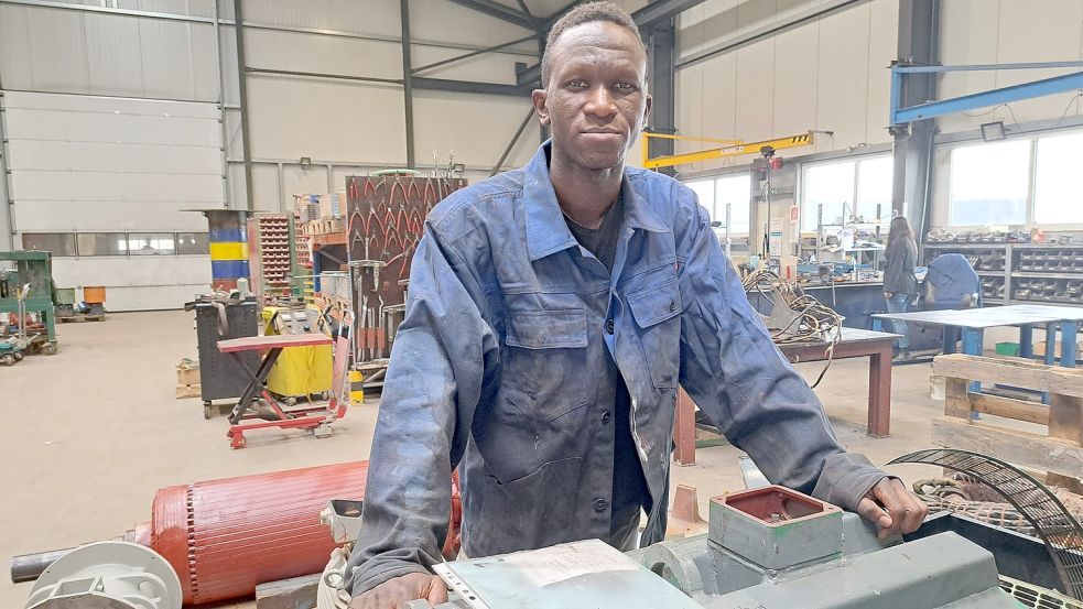 In der Produktionshalle der Seelan Elektromotoren GmbH in Weener: Für das Foto hat Abdoul Diallo noch mal eine Arbeitsjacke angezogen, doch die Ausländerbehörde hat ihm die Arbeitserlaubnis wieder entzogen. Foto: SZyska