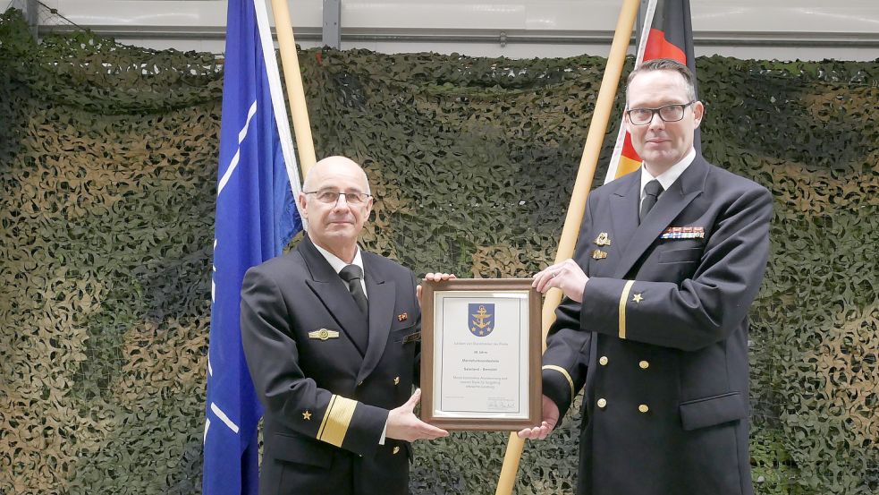 Flottillenadmiral Lars Holm (links) überreichte dem stellvertretenden Leiter der Marinefunksendestelle Ramsloh, Leutnant zur See Carsten Kröger, die Jubiläumsurkunde. Foto: Kruse