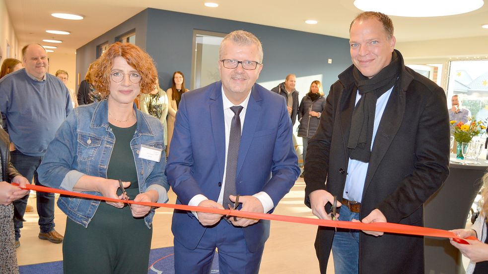 Krippenleiterin Anne Höppner (v.l.), Bürgermeister Theo Douwes und Andreas Schwerdt vom Architekturbüro Schomaker und Henschel schnitten gemeinsam das Band zur Eröffnung der Krippe durch. Foto: Weers