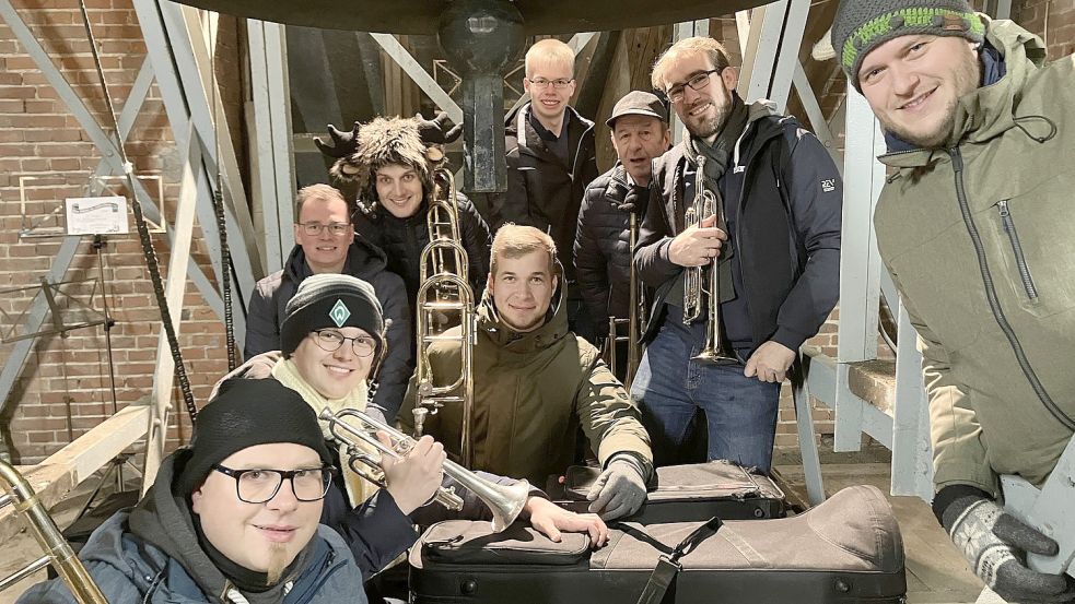 Die Musiker Andre Murra, Markus Schulte, Kevin Brand-Sassen, Manuel Ahrens, Malte Derke, Tobias Drees, Karl-Heinz Murra, Markus Ahrens und Thomas Bruse im Glockenturm der Kirche St. Georg. Foto: Ulrich Grever/Musikverein