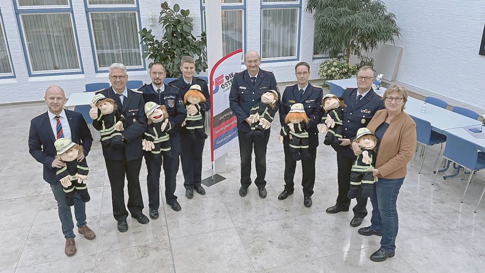 Sie freuen sich über die Aktion (von links): Tammo Keck von der Brandkasse, Erwin Reiners, Mario Eilers (stellvertretender Präsident des Feuerwehrverbandes Ostfriesland), Robert Friedrichs (Kreisbrandschutzerzieher in Leer und Sprecher des Arbeitskreises), Aron Janssen (Brandschutzerzieher in Emden), Uwe Holzknecht (Brandschutzerzieher in Wittmund), Friedhelm Saathoff (Kreisbrandschutzerzieher in Aurich) und Brandkassen-Sprecherin Signe Foetzki. Foto: Brandkasse