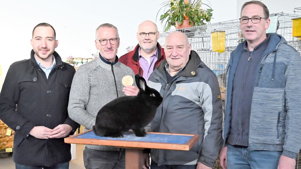 Eröffnung der 60. Kreisverbandsschau der ostfriesischen Rassekaninchenzüchter in Weener: (von links) Nico Bloem, SPD-Landtagsabgeordneter, Preisträger Hermann Nagel und sein Schwarzer Wiener, ausgezeichnet mit der Goldenen Medaille des Kreisverbandes Ostfriesland, Rüdiger Frers, stellvertretender Kreisverbandsvorsitzender, Focko Stöhr, Kreisverbandsvorsitzender, und Ausstellungsleiter Michael Goemann. Foto: Privat