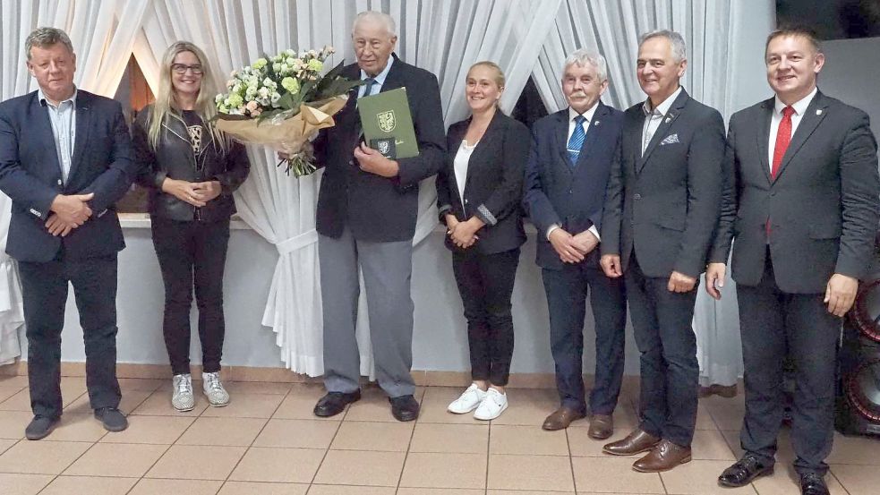 Der Saterländer Conrad Niemeyer mit Urkunde und einem großen Blumenstrauß anlässlich der Verleihung der Ehrenbürgerwürde im Kreis kommunaler Vertreter von Sroda Slaska, darunter Bürgermeister Adam Rucinski (rechts) und seinem Amtsvorgänger Boguslaw Krasucki (links). Archivfoto: privat