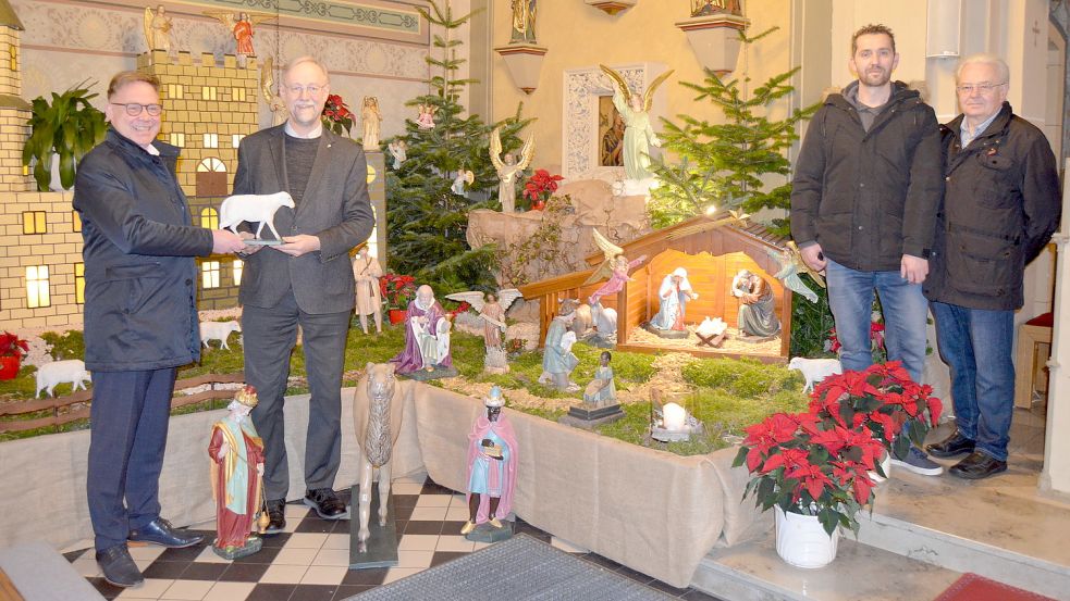 Freuen sich über die frisch restaurierte Krippe (von links) Frank Naber, Regionaldirektor Firmenkunden der Landessparkasse zu Oldenburg und Vorsitzender von deren Stiftung Kunst und Kultur, der Leitende Pfarrer der Kirchengemeinde St. Jakobus Saterland, Ludger Fischer sowie (rechts) das Ramsloher Krippenbau-Team, Sohn und Vater Wolfgang und Heinrich Böhmann. Foto: Fertig