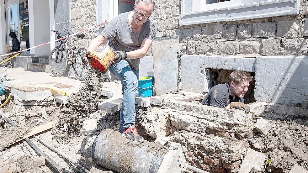 Stolberg wenige Tage nach der Flut: Zwei freiwillige Helfer räumen den Schlamm aus dem Keller einer Gaststätte. Foto: Marius Becker/dpa