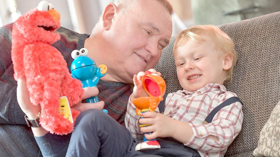 Theo spielt mit seinem Opa Karlheinz Harms aus Emden zu gern mit den Figuren Elmo, Krümelmonster und Ernie aus der Sesamstraße. Foto: Ortgies