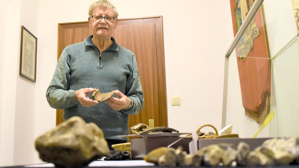 Spannender Fund: Heinz Frerichs mit einer Tonscherbe, die aus dem 9. Jahrhundert stammt und nun im Heimathaus Harkebrügge in einer Vitrine ausgestellt ist. Foto: Hahn