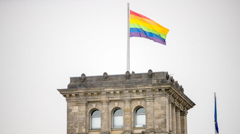 Die Regenbogenfahne wird anlässlich des Berliner Christopher Street Day (CSD) auf dem Südwestturm des Reichstagsgebäudes gehisst. Foto: Christoph Soeder/dpa Foto: Christoph Soeder
