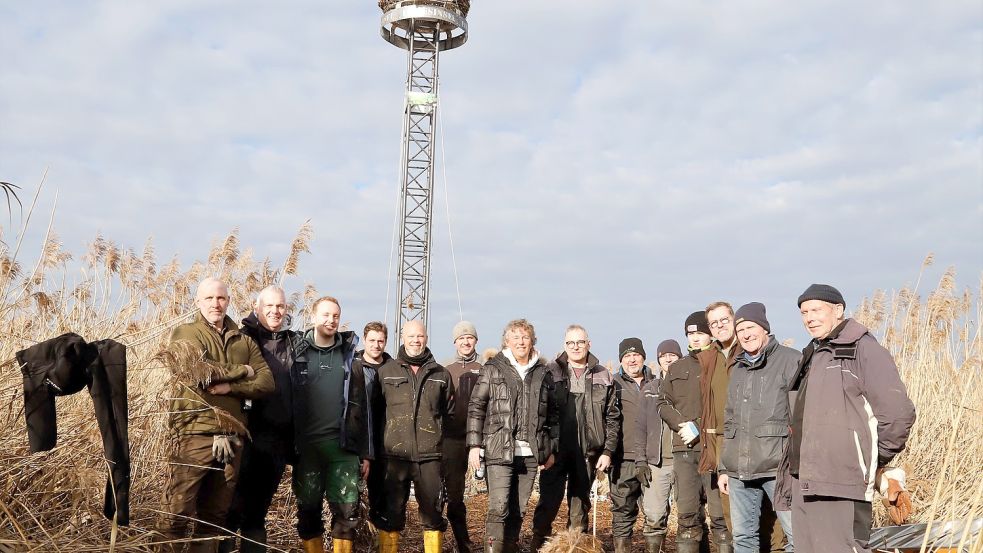 Zusammen mit dem Initiator Frank Wortmann (Bildmitte) aus Harkebrügge stellten Mitarbeiter, Bekannte und Freunde das Storchennest auf der Liebesinsel auf. Foto: Passmann