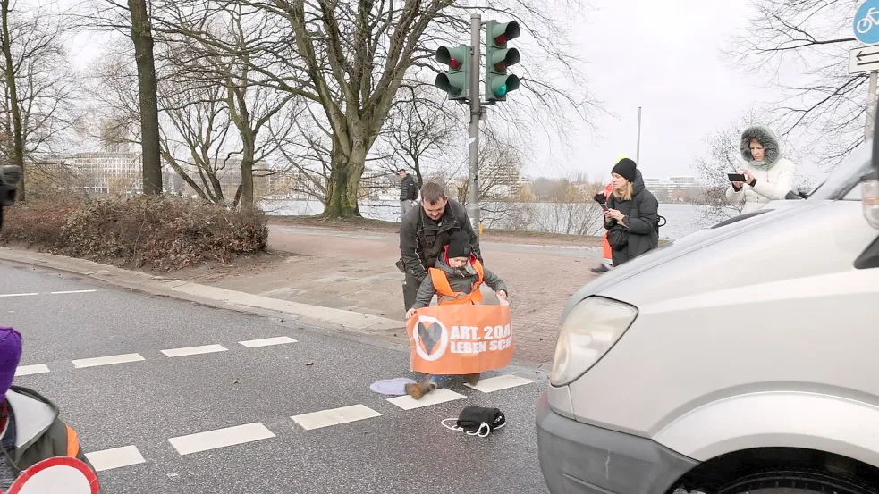 Ein Autofahrer zieht eine der Aktivistinnen von der Kennedybrücke. Foto: Lenthe-Medien/Reimer