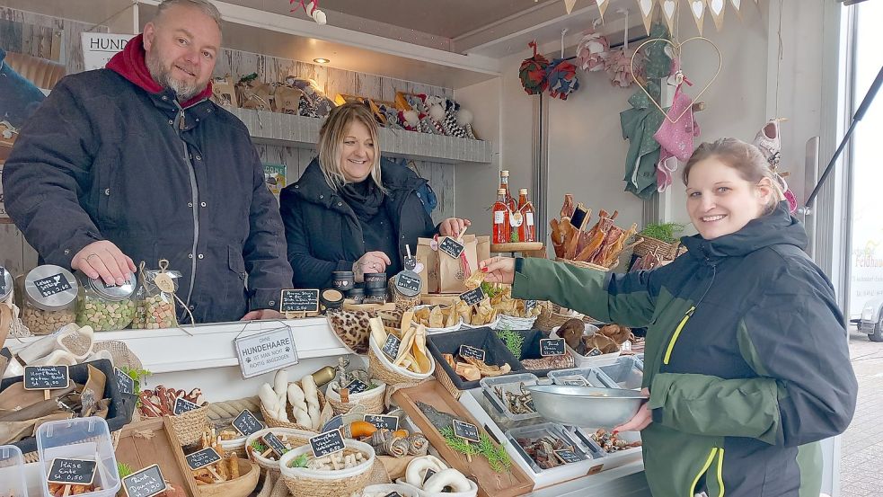 Das Interesse am Angebot von Andreas und Jannine Linnemeier auf dem Wochenmarkt Rhauderfehn ist groß. Samira Schneider (rechts) reiste für die Hundeleckerlis extra aus Hesel an. Foto: Scherzer