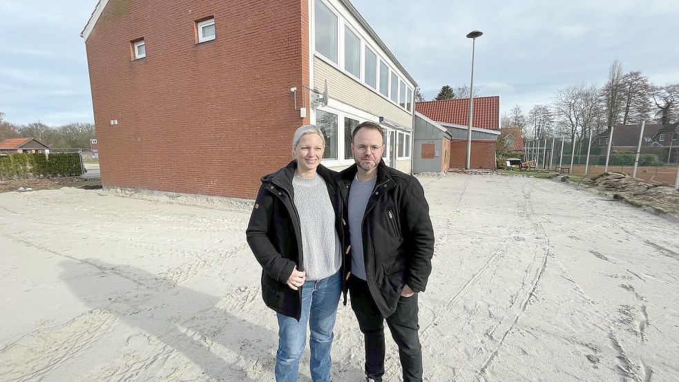 André und Michaela Di Nanni vor dem Altbau. Dort, wo jetzt der Sand liegt, wird der Erweiterungsbau entstehen. Foto: Janßen
