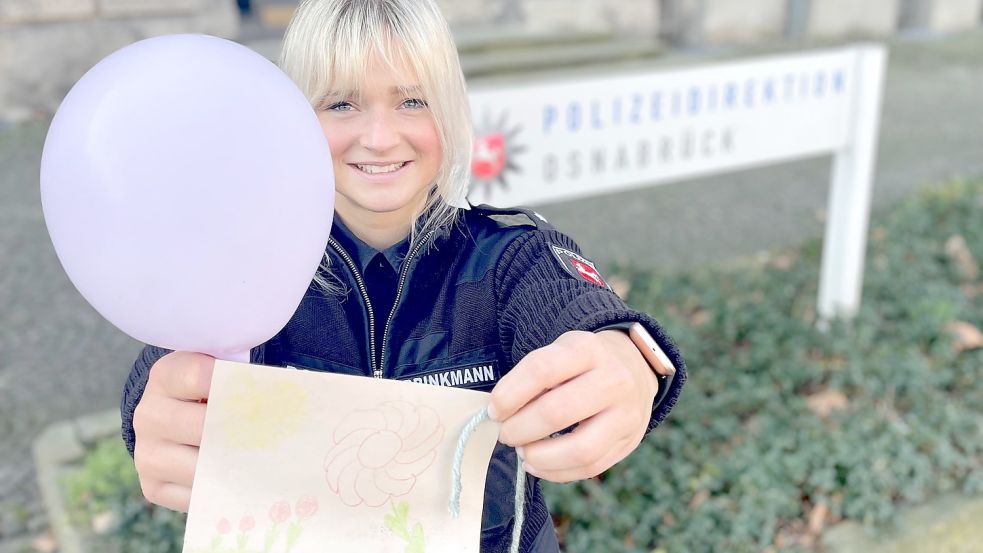 Osnabrücks Polizei-Sprecherin Laura Brinkmann hält den Luftballon hoch, der inklusive einer Karte auf dem Hof der Osnabrücker Polizei gefunden wurde. Abgeschickt wurde er auf dem Kindergeburtstag von Friederike Ammermann aus Langholt. Foto: Polizeidirektion Osnabrück