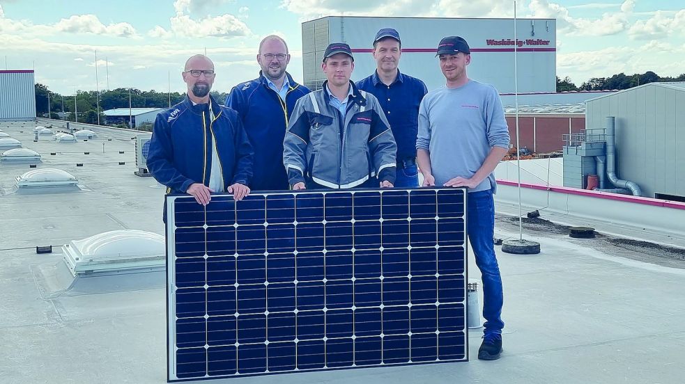 Auf dem Dach stehen hier mit einem der mehr als 6000 Solarpanels (von links): Herbert Warnecke und Konstantin Zitzer (EWE) sowie Christian Rumkamp, Gerold Többen und Nils Sassen (Waskönig+Walter). Foto: W+W