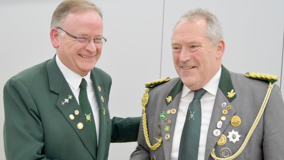 Detlef Temmen (links), Präsident des Ostfriesischen Schützenbundes, gratuliert Karl-Gerhard Laaken zur Wiederwahl als Präsident des Kreisverbandes Bund der Overledinger Schützen. Fotos: Weers