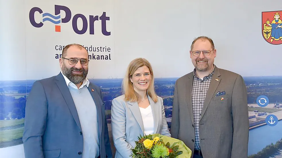 Begrüßung am Küstenkanal mit Blumen: Sven Stratmann (links) und Thomas Otto als Vertreter der beiden C-Port-Gesellschafter, Stadt Friesoythe und Gemeinde Saterland, freuen sich auf die Zusammenarbeit mit der neuen Geschäftsführerin Inke Onnen-Lübben. Foto: C-Port am Küstenkanal