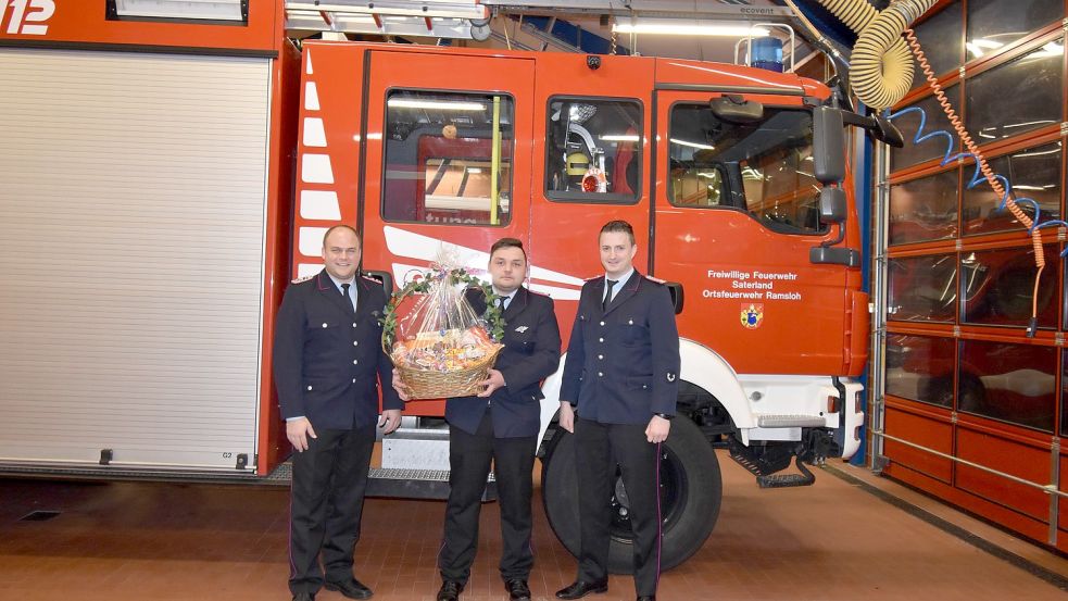 Einen Präsentkorb bekam der Feuerwehrmann des Jahres 2022 (von links): stellvertretender Ortsbrandmeister Timo Hinrichs, Malte Bümmerstede und Ortsbrandmeister Matthias Schulte. Foto: Thomas Giehl/Feuerwehr Saterland