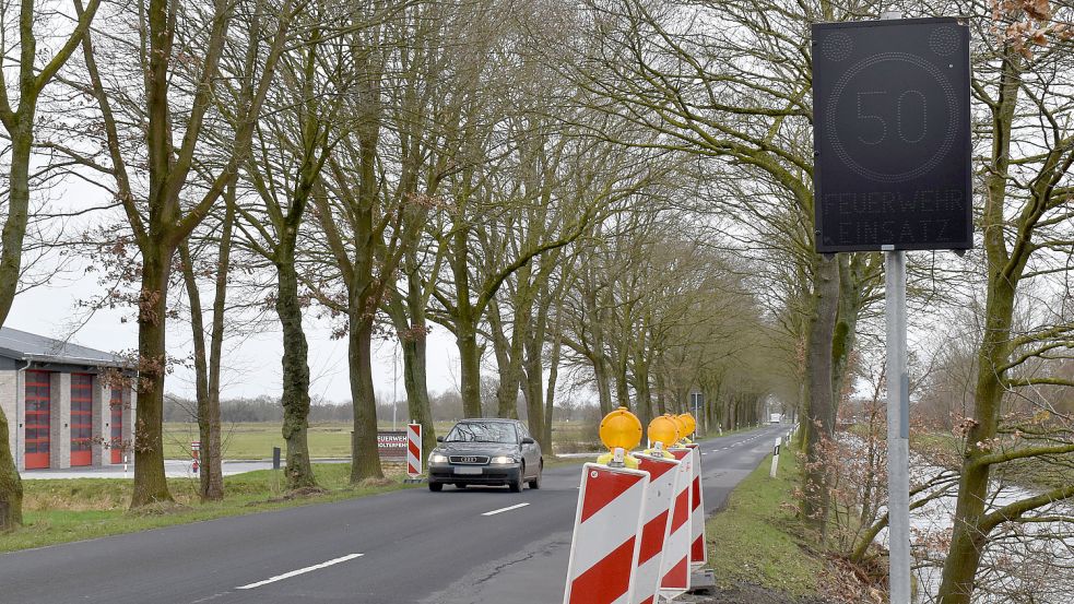 Auf der Holterfehner Straße in Holterfehn wurden jetzt zwei LED-Tafeln aufgestellt. Eine davon ist rechts zu sehen. Wenn die Feuerwehr von ihrem Standort - links im Bild ist das Feuerwehrhaus - ausrückt, dann warnen diese Tafeln die Autofahrer. Fotos: Zein