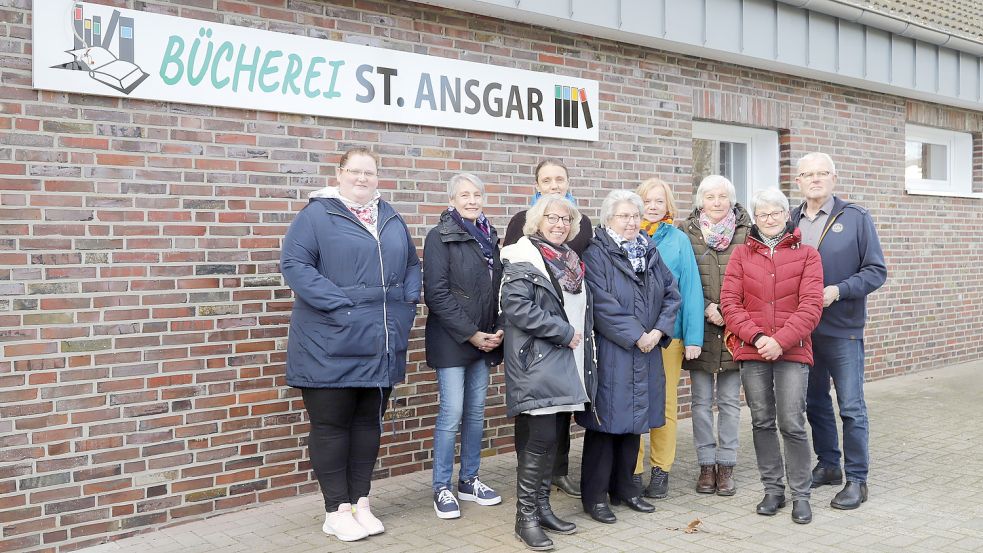 Vor dem neuen Schriftzug freut sich das Leitungsteam der Bücherei St. Ansgar Barßel auf die Neueröffnung und auf die sanierten Räumlichkeiten. Foto: Passmann