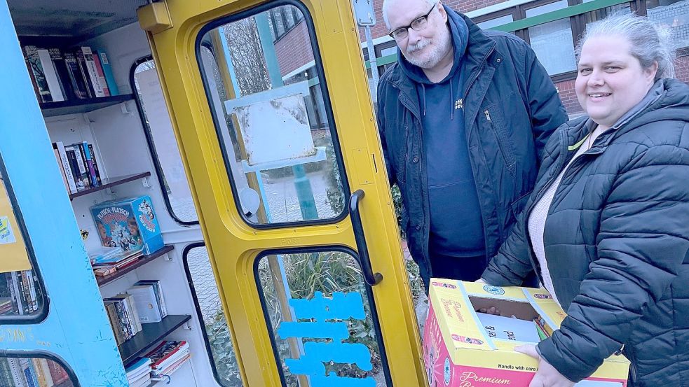 Da war die Scheibe noch heil: Vor wenigen Tagen sortierten Sandra Gräfenstein-Plaisier und Detlef M. Plaisier Lesestoff in die Bücherzelle am Rathaus ein. Foto: Janßen