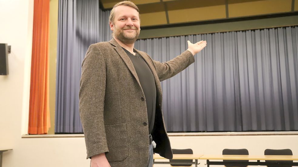Der 42jährige Tjaark Philipp Meyer aus Barßel, der hier mit ausladender Geste auf die Bühne der IGS Barßel weist, möchte auf dieser Bühne gerne das Musical „Linie 1“ aufführen. Foto: Passmann