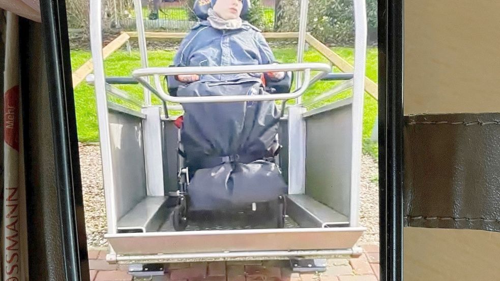 Marion Schlenkermann zeigt ein Handyfoto, das sie von ihrem Sohn in der Schaukel der Tagesförderstätte Bunde gemacht hat. Foto: Janßen