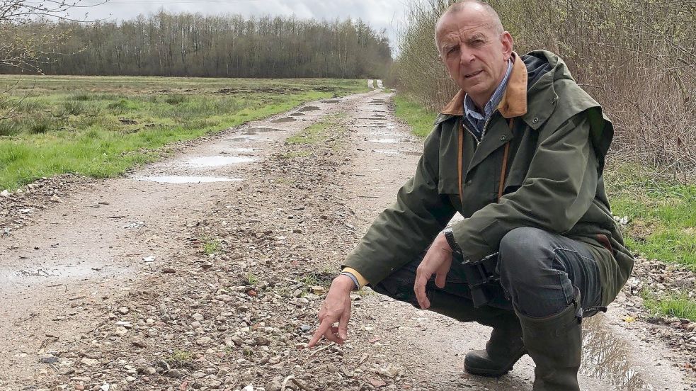 Der frühere Berufssoldat Thomas Bigalke zeigt an diesem Mittwoch auf einen aus Bauschutt befestigten Weg in der Esterweger Dose in Ramsloh Höhe Idafehn-Süd.