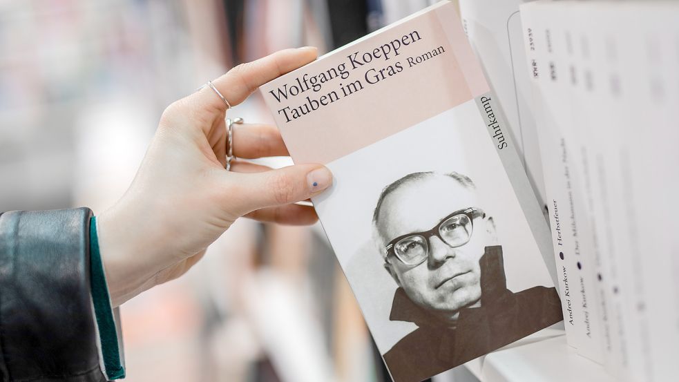 Darf dieser Roman noch einen Platz im Deutschunterricht haben? Eine Frau hält in einer Buchhandlung das Buch „Tauben im Gras“ von Wolfgang Koeppen in ihrer Hand Foto: dpa