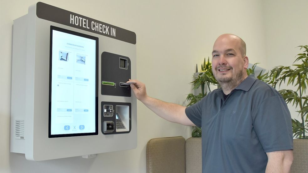 Alles automatisiert: Betreiber Matthias Bley erklärt, dass der Checkin-Kiosk einfach zu bedienen ist und am Ende die Zimmerkarte auswirft. Foto: Hahn