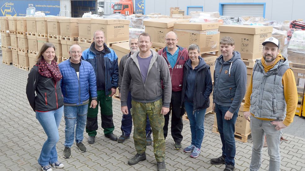 Das Foto zeigt Michael Kröger (5. von links) mit den Fahrern der Lkw. Im Hintergrund sind die gespendeten Hilfsgüter zu sehen. Foto: Weers