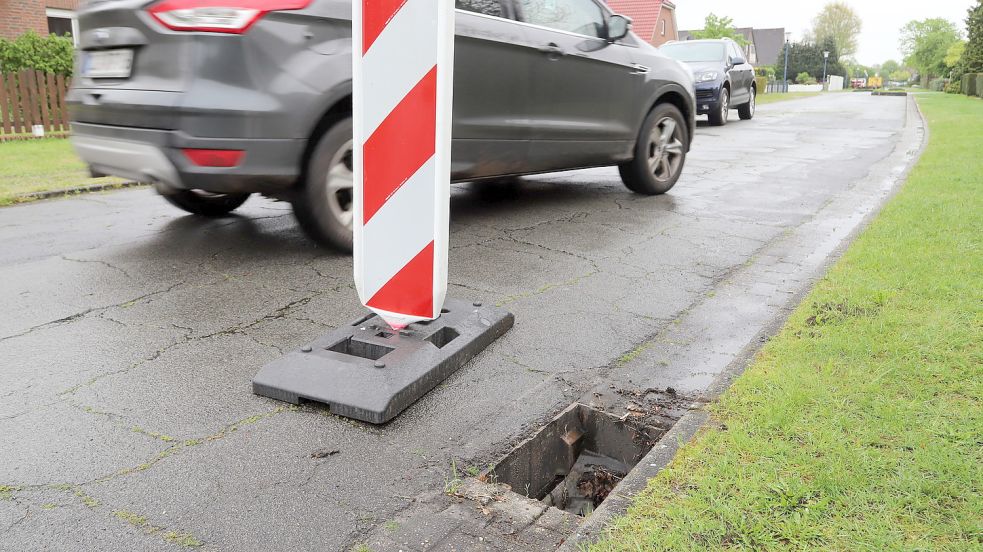 An der Ulmenstraße und auch anderswo im Barßeler Ortsteil Neuland fehlen seit Wochen Gullydeckel. Es handelt sich um Fälle von Vandalismus. Die Gemeinde hat die offenen Schächte mit Baken gekennzeichnet. Doch ersetzt werden die Abdeckungen nicht. Foto: Passmann