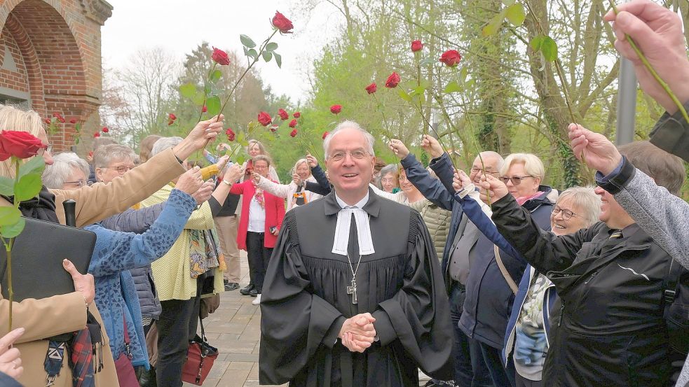 Lektoren und Prädikanten aus dem Sprengel Ostfriesland-Ems verabschiedeten sich von Regionalbischof Dr. Detlef Klahr mit einem Rosenspalier vor der St. Martin-Kirche in Potshausen. Foto: Hannegreth Grundmann/Sprengel