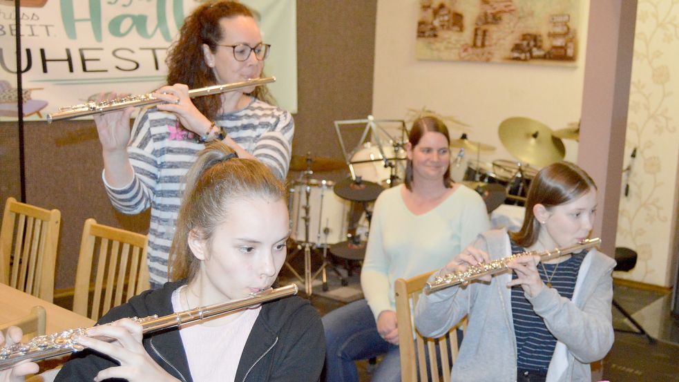 Der Musikverein Strücklingen darf wieder musizieren. Das Foto zeigt (vorne von links) Paula Reinken und Laura Rahrt, die mit ihren Querflöten für die Aufnahmeprüfung für das Jugendorchester im Musikverein üben. Ihre Ausbilderin und 2. Vorsitzende Stefanie Zimmermann (links) und die Vereinsvorsitzende Kathrin Murra (rechts) schauen interessiert zu. Foto: Weers