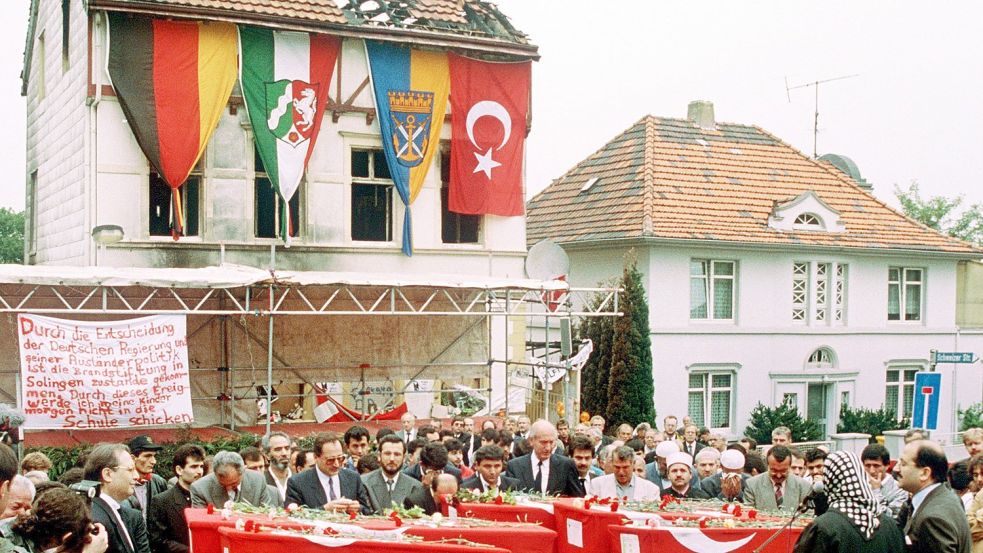 Die Särge der fünf bei dem Brandanschlag getöteten Mädchen und jungen Frauen stehen vor der Brandruine in Solingen. Am 29. Mai 1993 steckten Männer das Wohnhaus der Familie Genc aus rassistischen Motiven in Brand. Foto: dpa