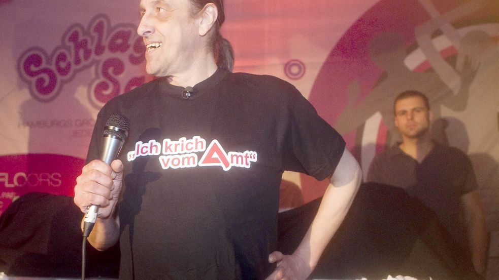 Der Langzeitarbeitslose Arno Dübel, bekleidet mit einem T-Shirt mit der Aufschrift „Ich krich vom Amt“, versuchte mal als Sänger Fuß zu fassen. Sein Song „Der Klügere kippt nach“ erwies sich jedoch als ziemlicher Reinfall. Foto: imago images/Lars Berg