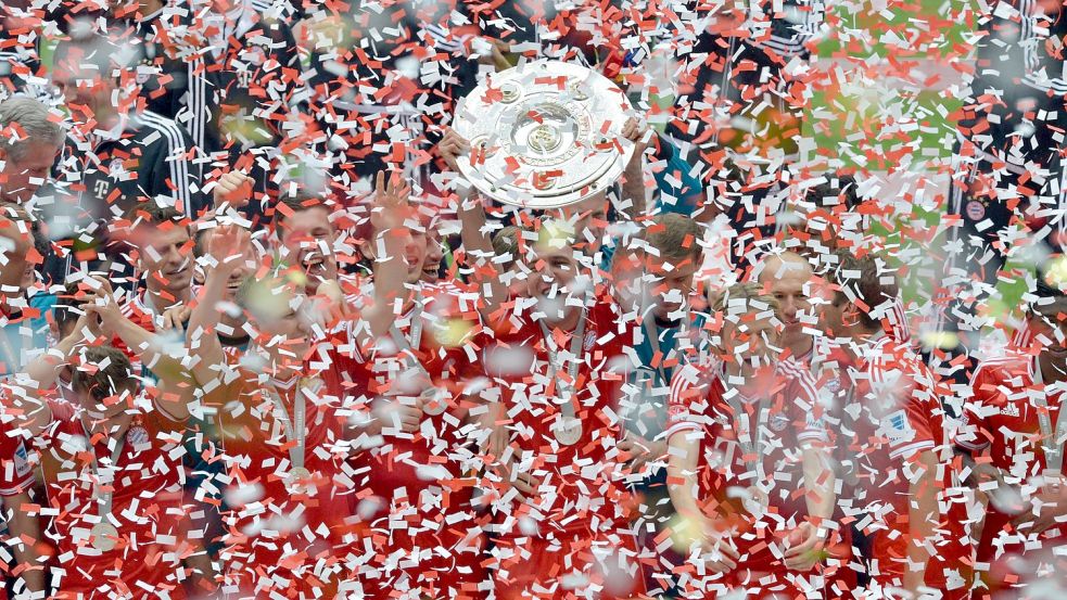 Die Spieler des FC Bayern München jubeln 2013 mit der Meisterschale. Foto: Peter Kneffel/dpa