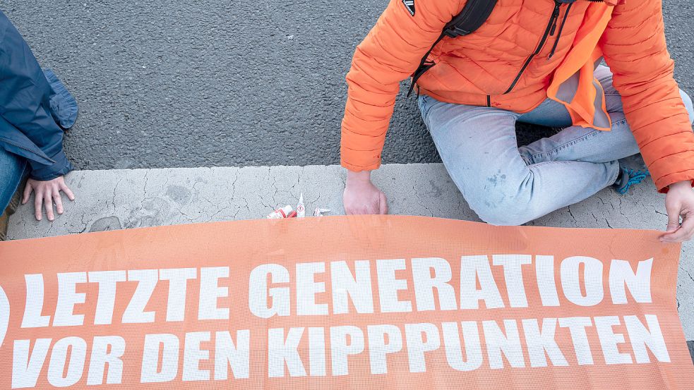 Ein Klimademonstrant der Letzten Generation hat seine Hand an der Straße festgeklebt. Wegen seiner Protestaktionen hat ein Klimaaktivist nun mit einer hohen Geldstrafe zu kämpfen und bittet um Spenden. Foto: imago images/Olaf Schuelke