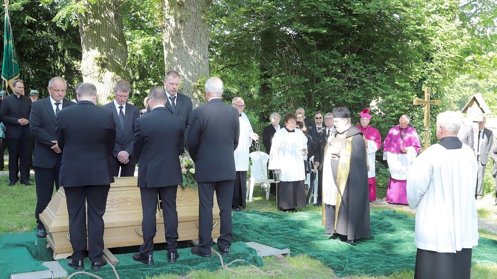 Ein Moment des Innehaltens und der Andacht, bevor der Sarg der Erde anvertraut wird. Foto: Passmann