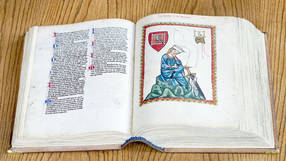 Eine originalgetreue Reproduktion des Codex Manesse, auch Große Heidelberger Liederhandschrift genannt, liegt in der Universitätsbibliothek auf einem Tisch. Auf einer der beiden aufgeschlagenen Seiten ist ein Abbild des Mittelalter-Lyrikers Walther von der Vogelweide zu sehen. Foto: dpa