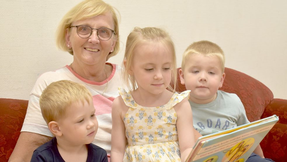 Kita-Leiterin Traute Doeden hat immer gerne mit Kindern zusammengearbeitet. Auf diesem Foto zeigt sie (von links) Maximilian, Sofia und Lukas ein Bilderbuch. Foto: Zein